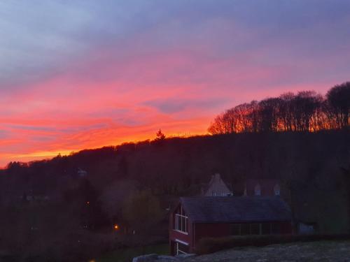 a sunset with a house in the foreground at Villa de la Sablière in Amougies