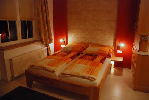 1 dormitorio con 1 cama en una habitación con paredes rojas en FeWo Burgstaller, en Tröpolach