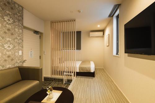 a hotel room with a bed and a couch at GRAND BASE Yakuin Odori in Fukuoka