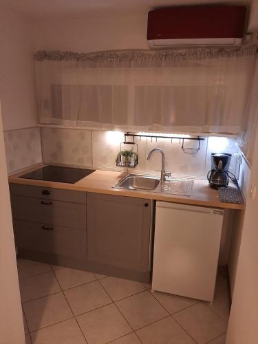 a small kitchen with a sink and a counter at Bed and Breakfast BLUE in BLUE in Komiža