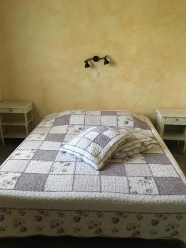 a bedroom with a bed with a checkered blanket at Joëlle et Daniel in Entrevaux