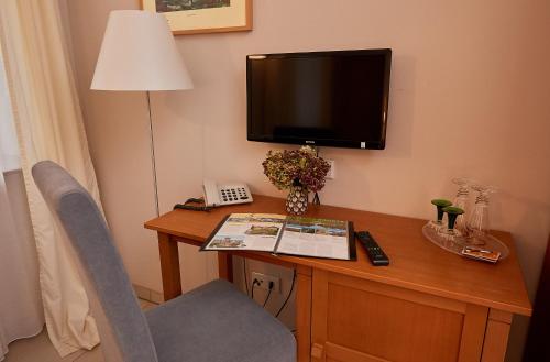 Zimmer mit einem Schreibtisch mit einem TV und einem Schreibtisch sidx sidx sidx. in der Unterkunft Am Malerweg in Pirna