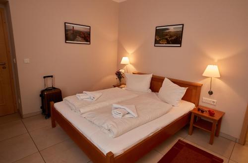 a bedroom with a bed with white sheets and pillows at Am Malerweg in Pirna