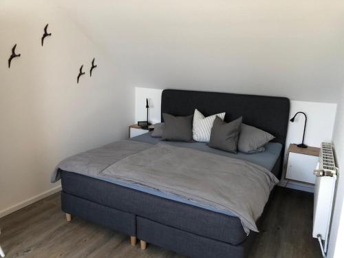 a bedroom with a large bed with birds on the wall at Quartier Meerblick in Fehmarn
