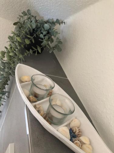a shelf with two glasses and a potted plant at Quartier Meerblick in Fehmarn