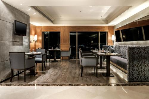 a restaurant with tables and chairs in a room at Hyatt Ahmedabad in Ahmedabad
