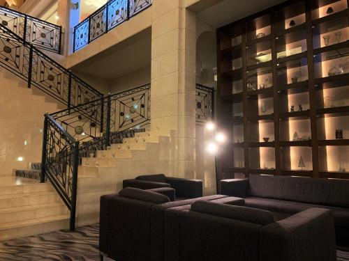a lobby with couches and stairs in a building at Nishiizu Crystal View Hotel in Nishiizu
