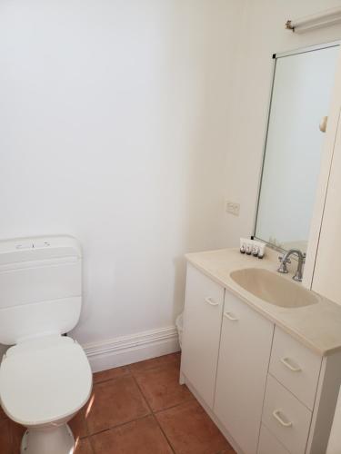 a bathroom with a white toilet and a sink at Marlo Hotel in Marlo