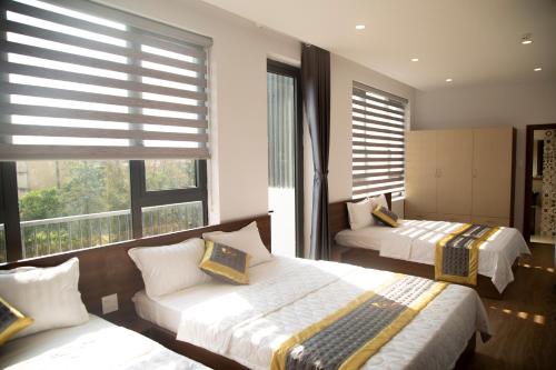 1 dormitorio con 2 camas y 2 ventanas en Khách sạn Phú Yên - BaKa Hotel, en Tuy Hoa
