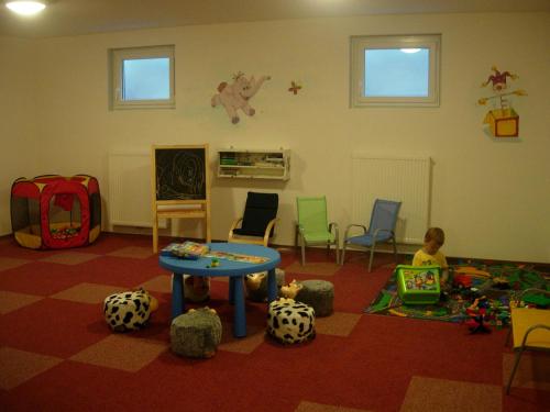 a room with a table and chairs and a child at Landhaus Fingerhof in Flachau