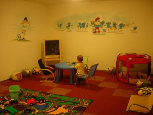 a child sitting at a table in a room at Landhaus Fingerhof in Flachau