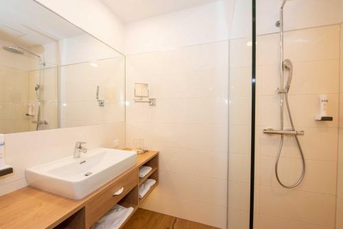 a bathroom with a sink and a shower at Hotel-Restaurant Gruber in Pöllau