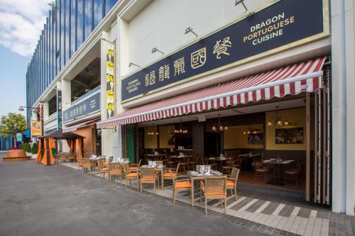 a restaurant with tables and chairs outside of a building at Broadway Hotel in Macau
