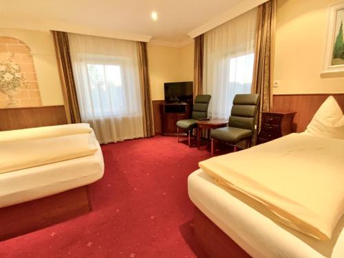 a hotel room with two beds and a desk and chairs at Villa Turnerwirt in Salzburg
