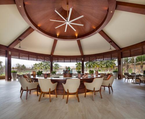 a dining room with a large clock on the wall at Fusion Resort Cam Ranh - All Spa Inclusive in Cam Ranh