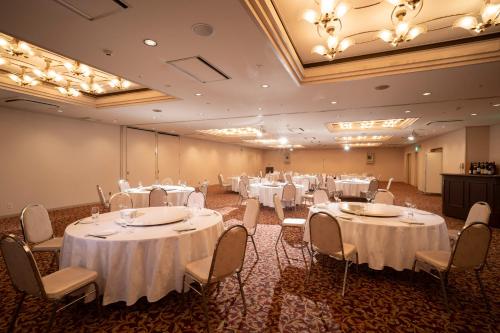 a banquet hall with white tables and chairs at Hotel Green Park Suzuka in Suzuka