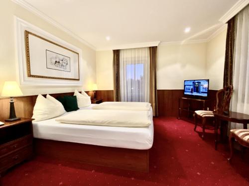 a hotel room with a bed and a television at Villa Turnerwirt in Salzburg