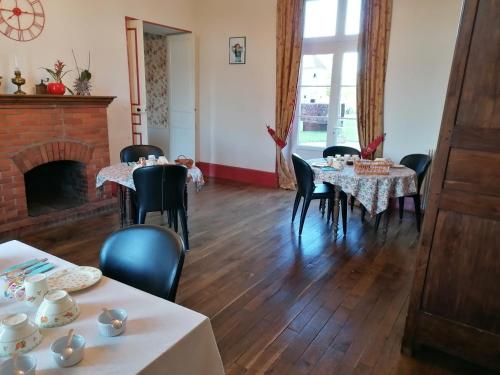une salle à manger avec des tables, des chaises et une cheminée dans l'établissement CHATEAU DE CHAVANNES, à Tresnay