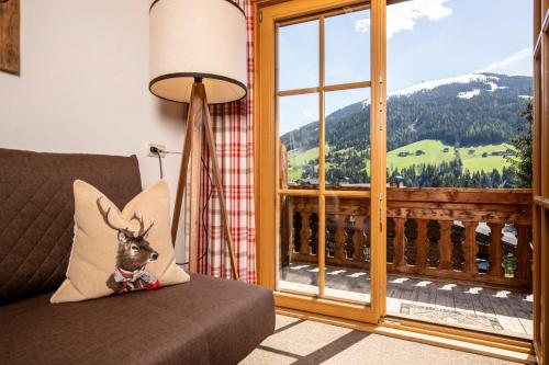 a room with a couch and a large window at Gästehaus Gratlspitz in Alpbach