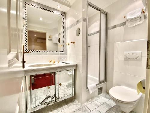 a bathroom with a toilet and a sink and a mirror at Villa Turnerwirt in Salzburg