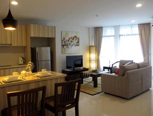 a living room with a kitchen and a living room with a couch at Samsuria Beach Apartment Resort in Cherating