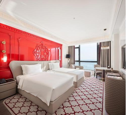 a bedroom with two beds and a red wall at Jin Bei Palace Hotel in Sihanoukville