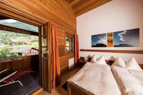 a bedroom with a bed and a large window at Hotel Glocke in Reckingen - Gluringen