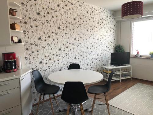 a kitchen with a white table and four chairs at Feels like Arctic City in Rovaniemi