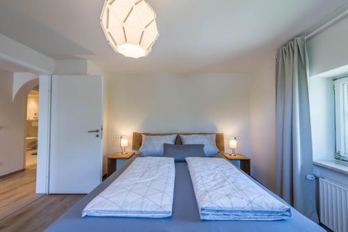 a bedroom with a large bed with two lamps on tables at Ferienwohnung Julia in Taching am See