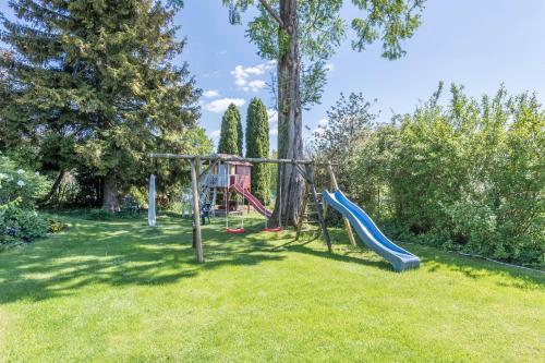 a playground with a slide in a yard at Ferienwohnung Julia in Taching am See
