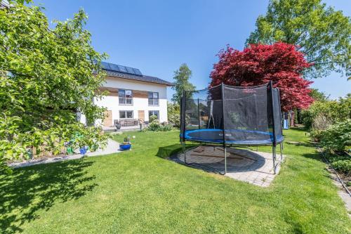 a trampoline in the yard of a house at Ferienwohnung Julia in Taching am See