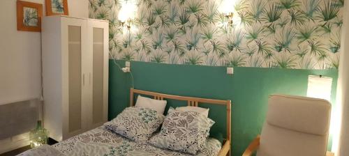 Habitación pequeña con cama y pared verde en Appartement / Jungle en Sète