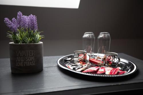 a tray of food and a vase with purple flowers at Urban 7 Residence in Bucharest