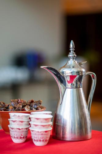 a tea kettle and bowls of food on a table at Holiday Inn Muscat AlSeeb by IHG in Muscat