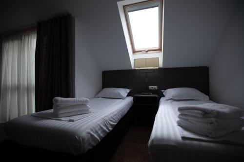 two twin beds in a room with a window at Urban 7 Residence in Bucharest