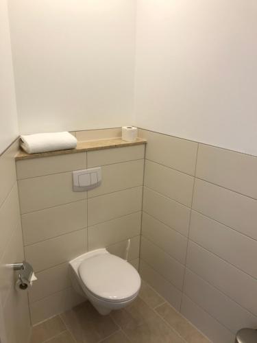 a bathroom with a white toilet and a shelf with a towel at Haidhus in Reinbek