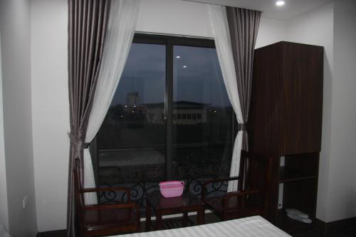 a bedroom with a window with a view of a city at SUN HOTEL & APARTMENT in Bắc Ninh