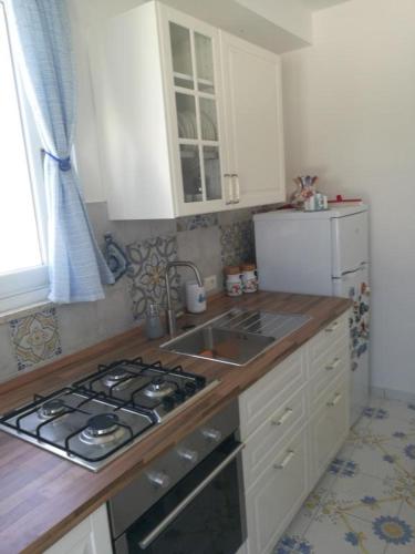 Agenzia Isotur MALVA في بونسا: مطبخ مع موقد ومغسلة وثلاجة
