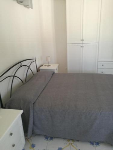 Agenzia Isotur MALVA في بونسا: غرفة نوم مع سرير وبطانية رمادية وخزانة