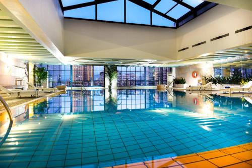 a swimming pool in a hotel with a large building at Grand Park Wuxi in Wuxi