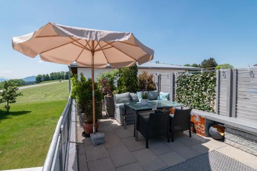 a patio with an umbrella and a table and chairs at Heimelig im Allgäu in Lindenberg im Allgäu