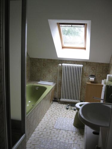 a bathroom with a green tub and a sink at Ferienwohnung H. Broschinski in Aurich