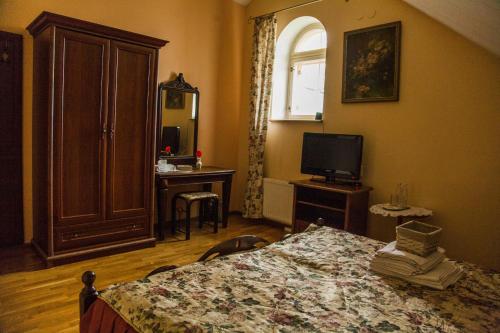 a bedroom with a bed and a television at U Pokrovki Guest House in Pskov