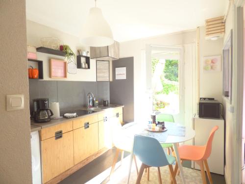 eine Küche mit einem Tisch und Stühlen sowie einem Tisch und einem Esszimmer in der Unterkunft Les Cocons de Stéphanie in Vichy