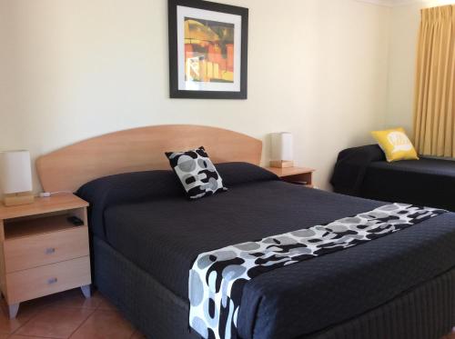 a bedroom with a bed with a black and white comforter at Pelican's Nest in Kalbarri