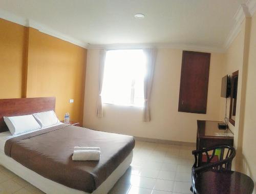 a bedroom with a large bed and a window at Tropicana Hotel in Gemas