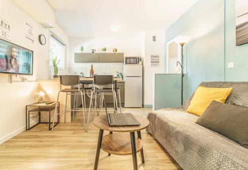 un salon avec un canapé et une table dans l'établissement Cosy Studio 108 - Chambéry centre - Stationnement - Gare, à Chambéry
