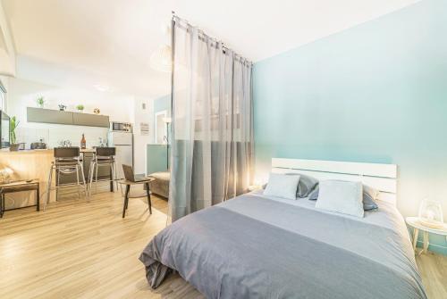 um quarto com uma cama grande e uma cozinha em Cosy Studio 108 - Chambéry centre - Stationnement - Gare em Chambéry