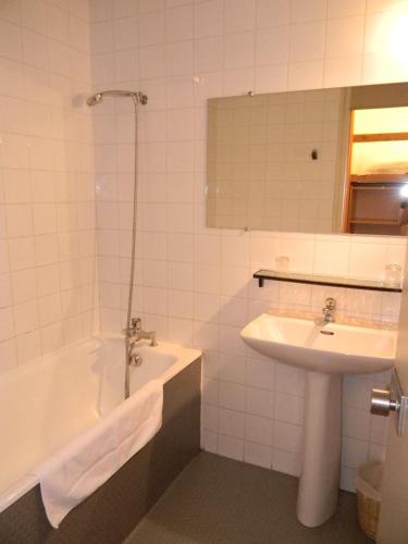 a bathroom with a sink and a bath tub and a sink at Le Logis des Cordeliers in Condom