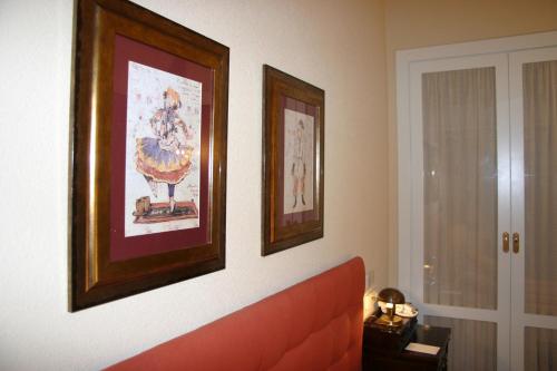 a living room with a couch and two pictures on the wall at Hotel Arcea Palacio de las Nieves in Langreo